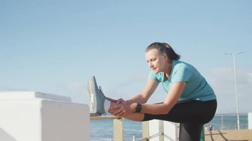 Senior woman stretching her legs on a promenade