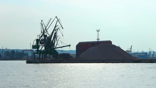 Silhouetten von Hafenkranen und Docks an der Küste, industrielle Infrastruktur