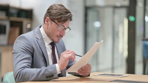Businessman Reading Documents in Office