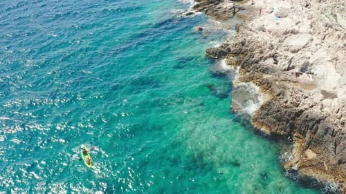 Tourists Sail Bright Kayak Along Tranquil Clear Sea Lagoon