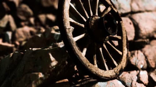 Time-Lapse of Weathered Wooden Wagon Wheel on Stone Wall