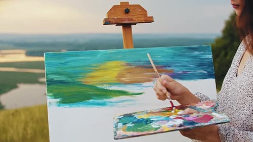 Artist Painting Landscape at Sunset in Countryside