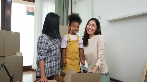 LGBT-Familie packt am Umzugstag Kartons im neuen Zuhause aus.
