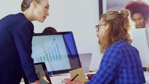 Executives interacting with each other while working at desk