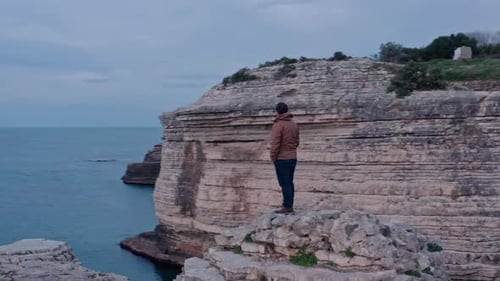 Orbiting Aroung Man Watching Sea From Top Of Rocks