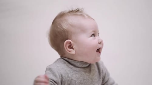 Porträt eines 6 Monate alten Babys auf hellem Hintergrund und lächelnd
