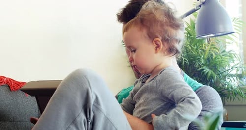 Father and Child using Tablet on Couch Indoors