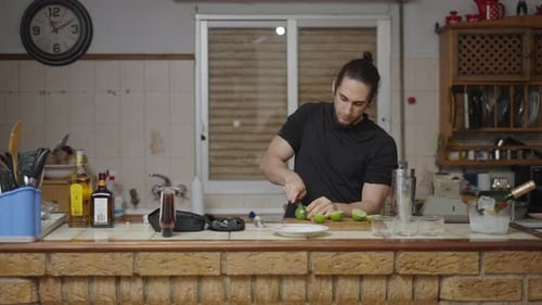 Man Prepares Limes for Cocktails at Kitchen Counter