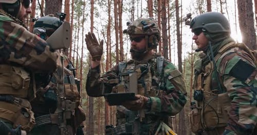 Soldiers Reviewing Tablet in Forest Wilderness