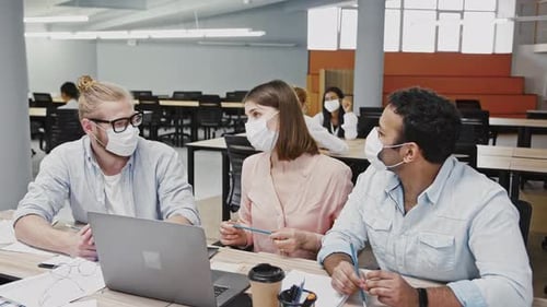 Three Adults Working Together at Table in Office