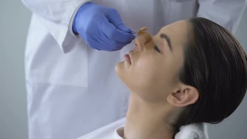 Bandage Removed Woman Looks at Face in Mirror
