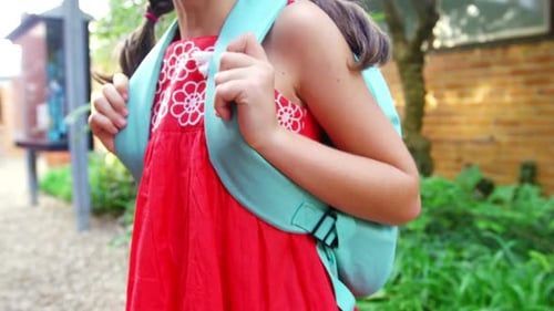 Portrait of happy schoolgirl standing in campus at school