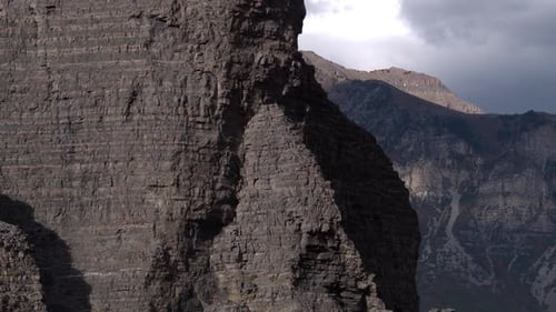 Aerial panning view of rocky cliff face revealing Mountain