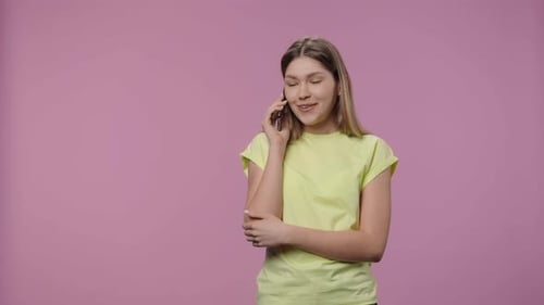 Woman Using Cell Phone Against Pink Background