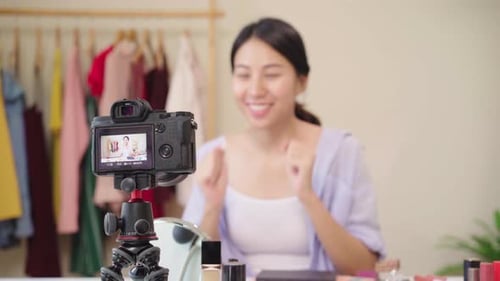 La bloguera de belleza presenta cosméticos de belleza sentada frente a la tableta para grabar un vídeo en la red social.