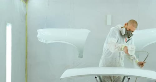 Mechanic painting car parts with electric spray gun 4k