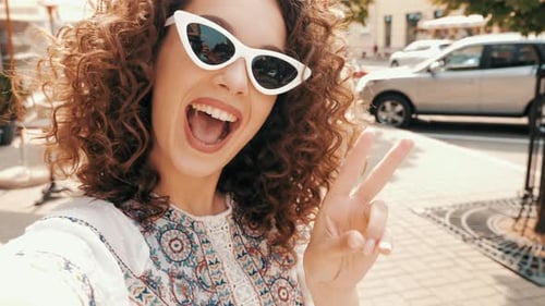 Young Woman Smiling and Waving in City