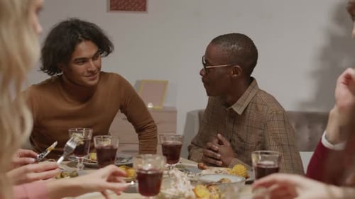 Friends Dining and Clinking Glasses Together Indoors