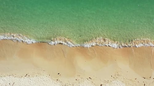 Wide angle aerial travel shot of a white sand paradise beach and turquoise sea background