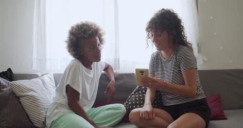 Women Friends Looking at Cellphone Indoors