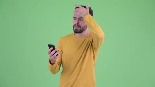 Bearded Man Using Cell Phone Appears Frustrated