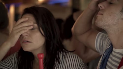 Football fans expressing disappointment while watching televised match in bar