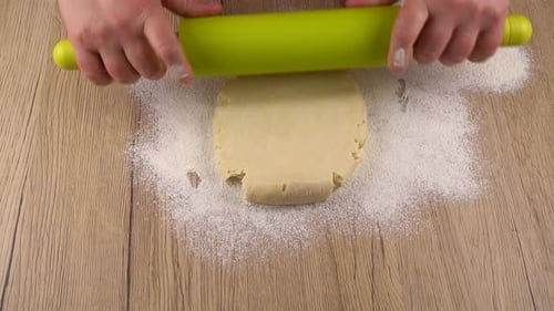 Hands Rolling Dough Flat with Rolling Pin