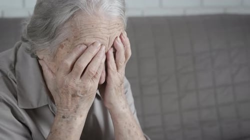 Sad Senior Woman Covering Face with Hands