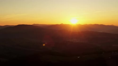 Malerischer Drohnenblick auf den strahlenden Sonnenuntergang am Abendhimmel über dem Bergrücken
