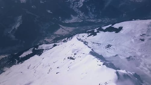 Images aériennes de Drone survolant un sommet enneigé au-dessus de la station de ski de Verbier, en Suisse