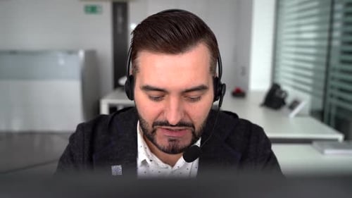 Technical Support Operator Working with Headset in Office