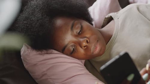 Woman Using Mobile Phone in Bed Close Up