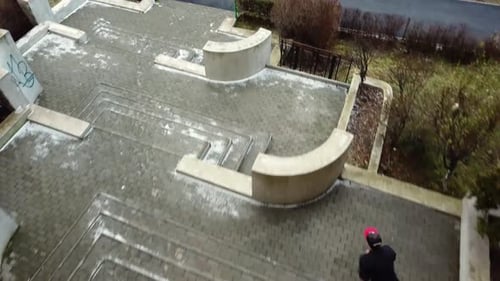 Stabilisierter Tracking-Schuss folgt hinter einem jungen erwachsenen männlichen Parkour-Freeläufer, der über Multi springt