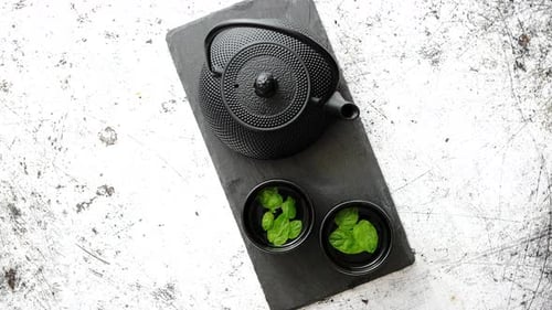Black Teapot with Mint on Slate Board