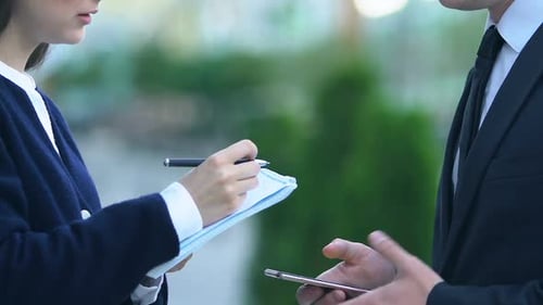 Le patron donne des instructions à une assistante prenant des notes et planifiant le calendrier