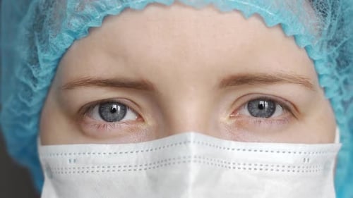 Close-up Portrait of a Doctor. The Doctor Opens His Eyes and Looks Directly at the Camera