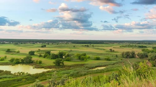 A Beautiful Valley with a River, Blue Sky with Large Clouds and Bright Sun. Aerial UHD