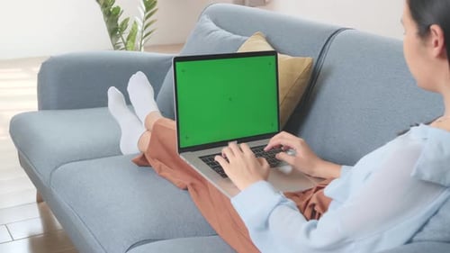 Asian Female Working On Laptop With Green Screen Mock Up Display