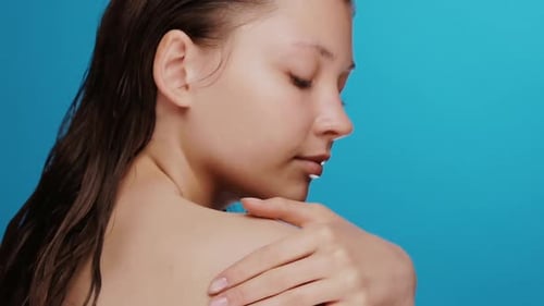 Woman Applying Lotion To Her Shoulder