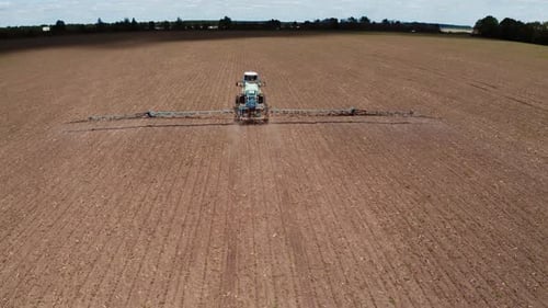 Tractor vehicles working at field. Aerial shots of the tractor while working in the field
