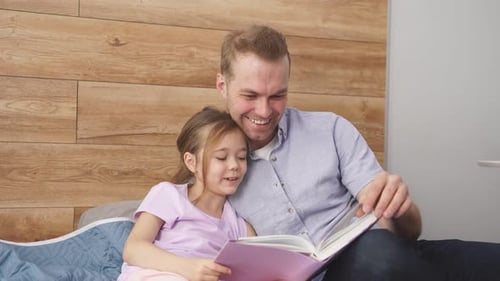 Father Reading a Book to Daughter at Home