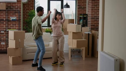 Excited Couple Dancing in New Home After Moving