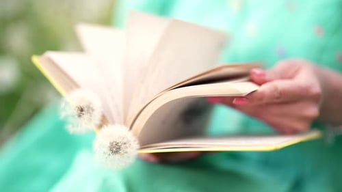 Woman Turns Over Pages of Old Paper Book