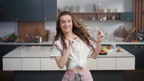 Woman Dancing and Smiling in Modern Kitchen
