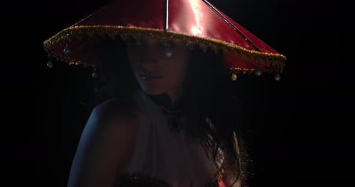 Woman Posing with Red Hat in Dark Studio