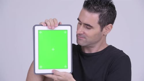 Man Holding Tablet with Green Screen Display