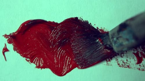 Drawing with a Paintbrush on White Paper with Red Oil Paint Closeup