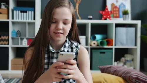 Girl Uses Smartphone Sitting Indoors