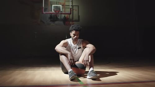 Porträt eines Basketballspielers auf dem Platz im Dunkeln