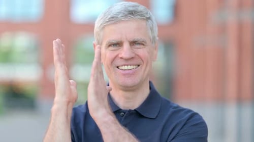 Smiling Adult Man Clapping Outside in City
